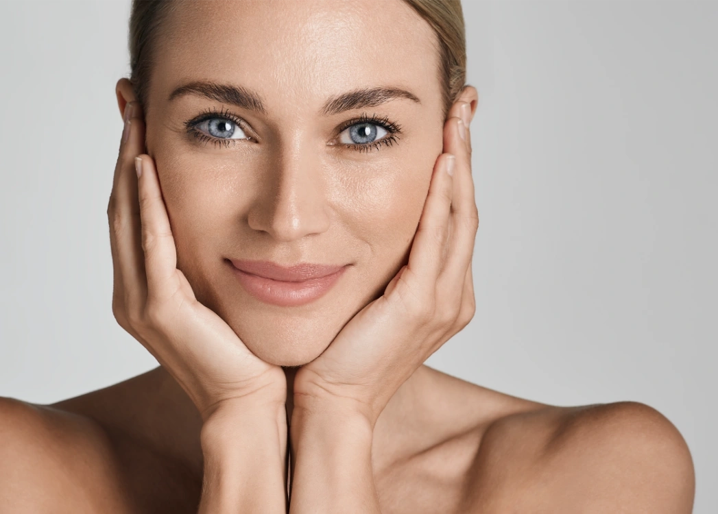 beautiful woman with healthy facial skin touching hands